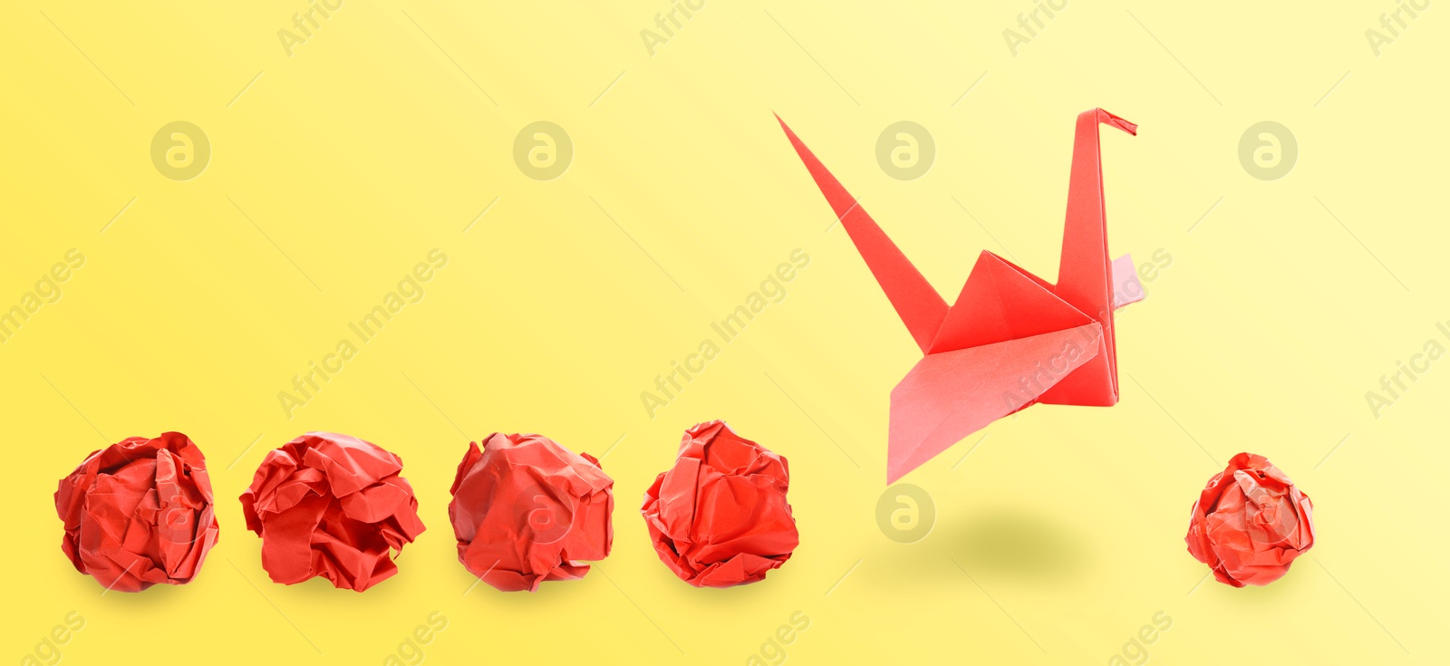 Image of Red origami crane and crumpled paper balls on yellow gradient background, banner design. Transformation or leadership concept