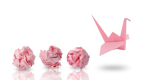 Image of Pink origami crane and crumpled paper balls on white background, banner design. Transformation or new ideas concept