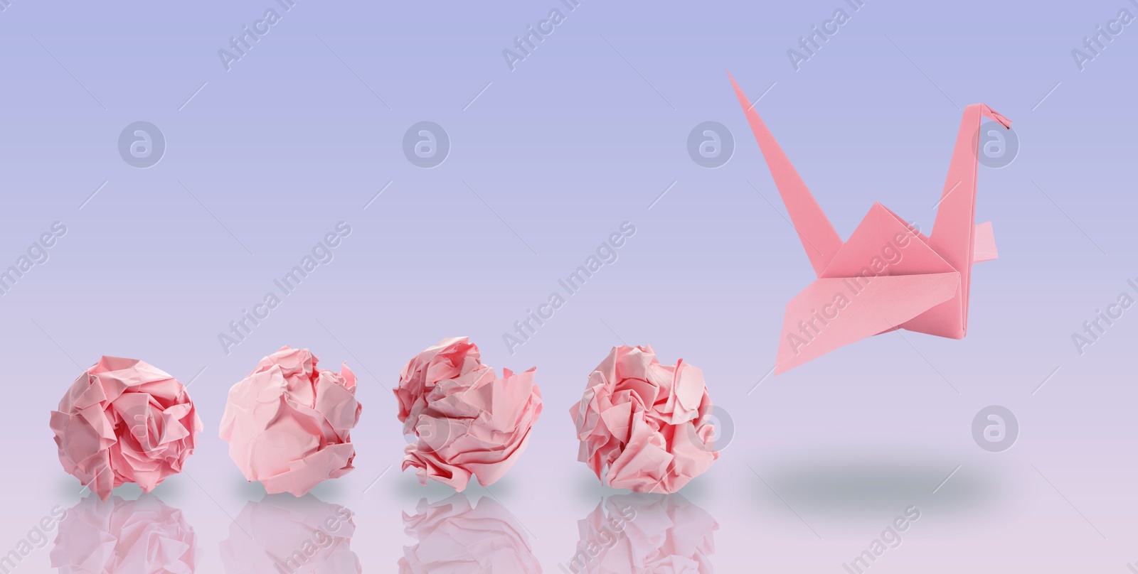 Image of Pink origami crane and crumpled paper balls on violet gradient background, banner design. Transformation or new ideas concept