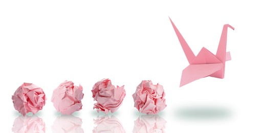 Image of Pink origami crane and crumpled paper balls on white background, banner design. Transformation or new ideas concept