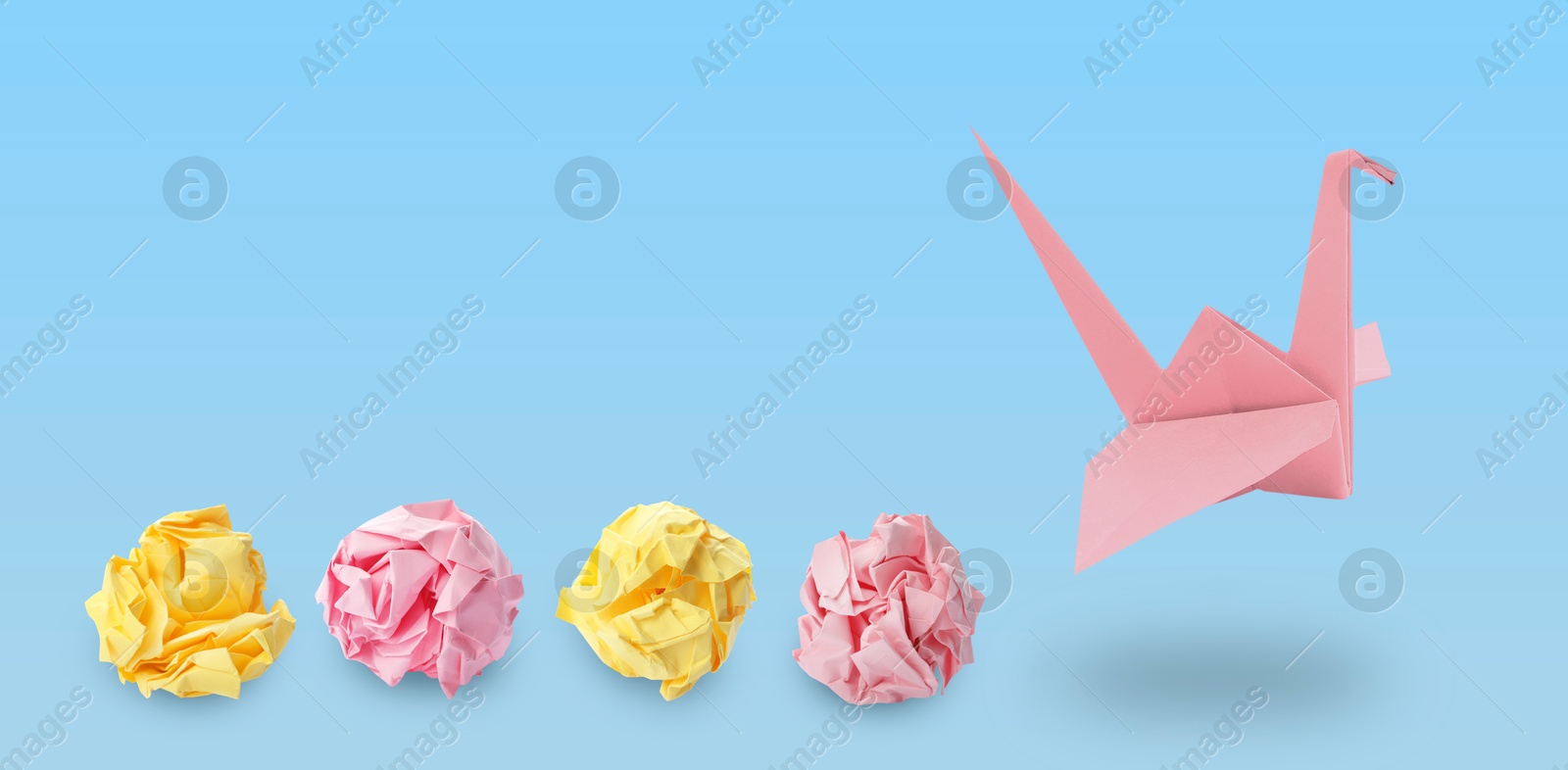 Image of Pink origami crane and crumpled paper balls on light blue background, banner design. Transformation or new ideas concept