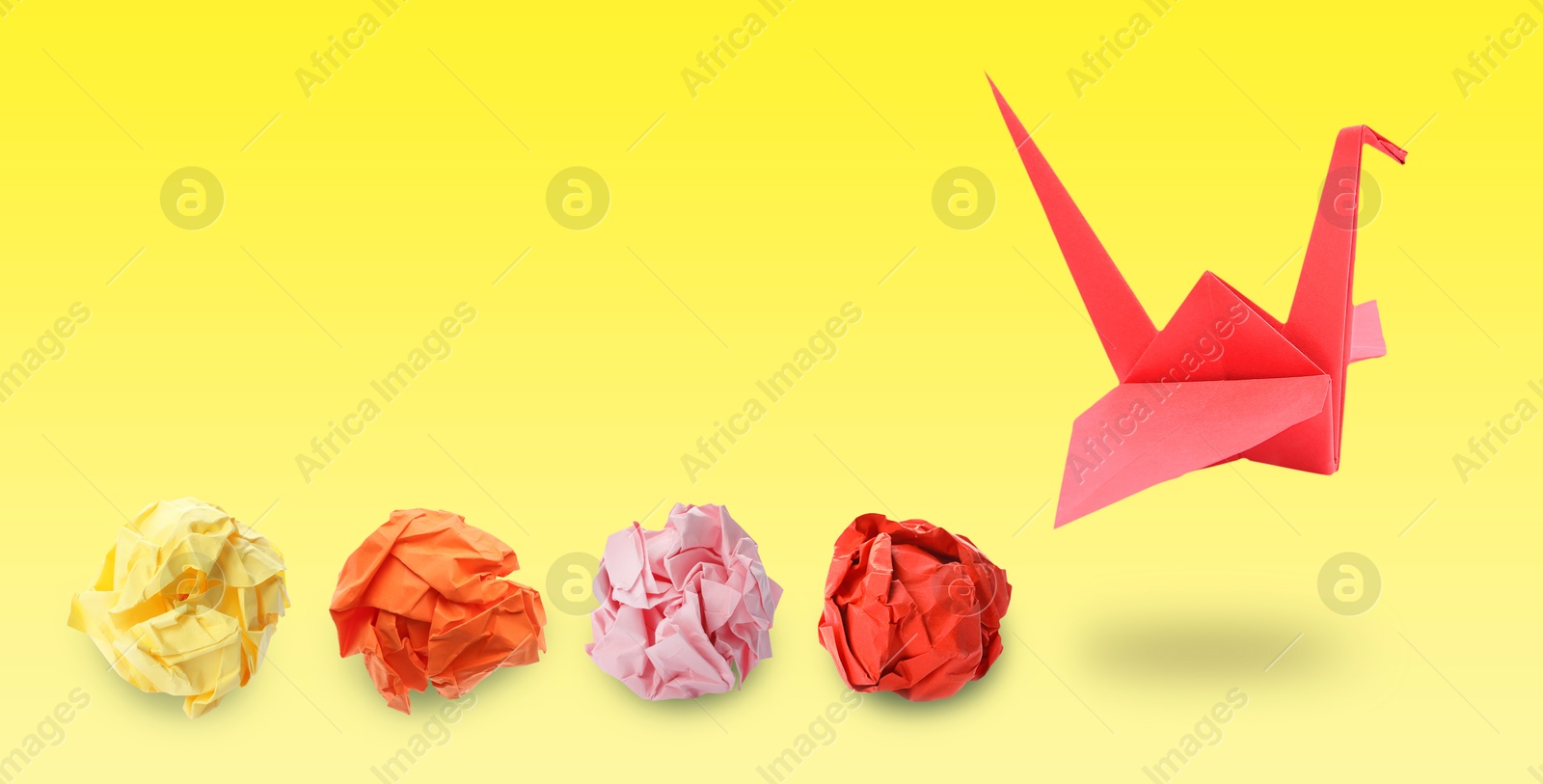 Image of Red origami crane and crumpled paper balls on yellow gradient background, banner design. Transformation or new ideas concept