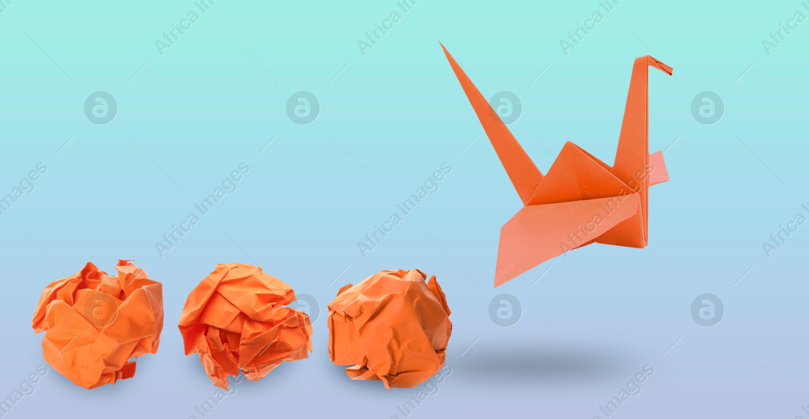 Image of Orange origami crane and crumpled paper balls on blue gradient background, banner design. Transformation or new ideas concept