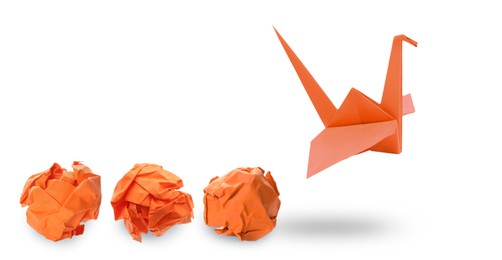 Image of Orange origami crane and crumpled paper balls on white background, banner design. Transformation or new ideas concept