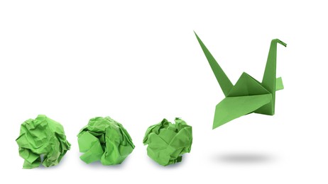 Image of Green origami crane and crumpled paper balls on white background, banner design. Transformation or new ideas concept