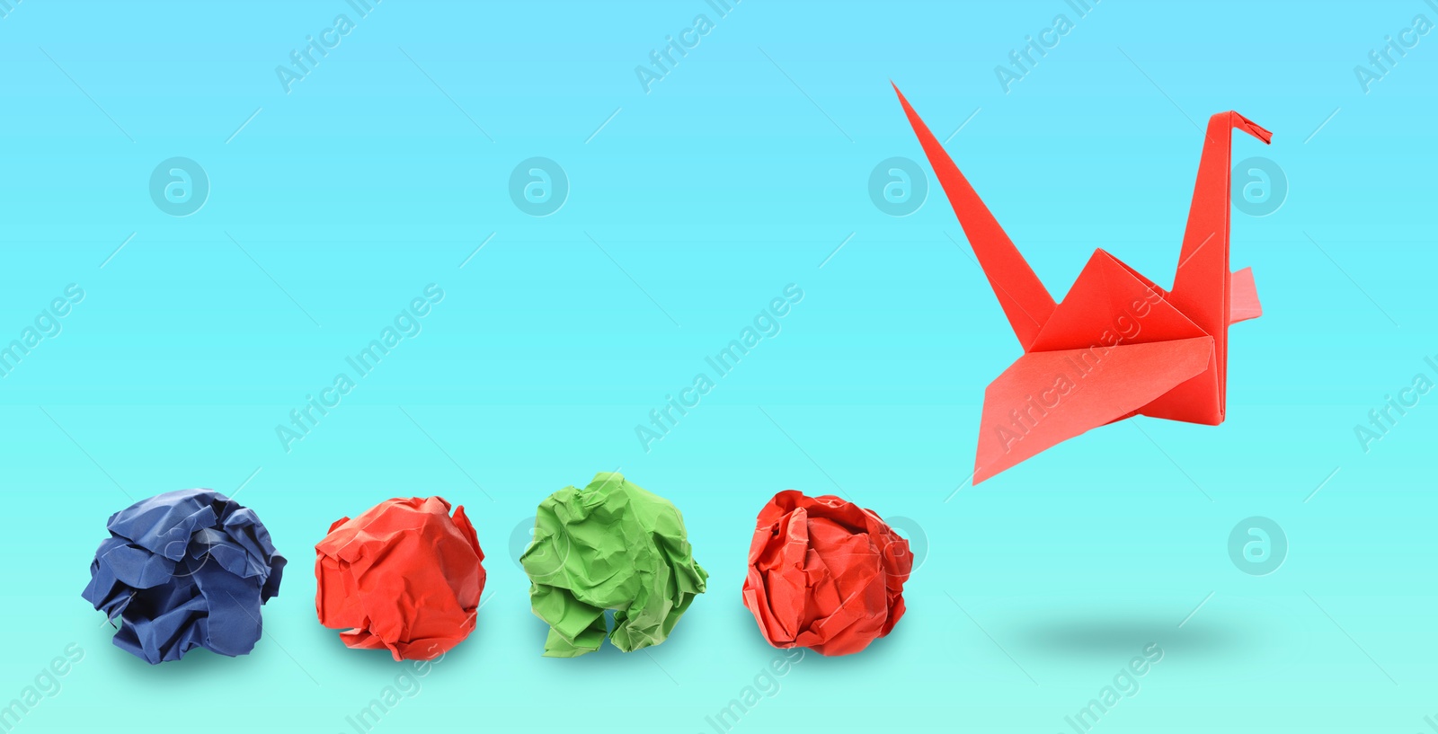 Image of Red origami crane and crumpled paper balls on blue gradient background, banner design. Transformation or new ideas concept