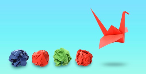 Image of Red origami crane and crumpled paper balls on blue gradient background, banner design. Transformation or new ideas concept