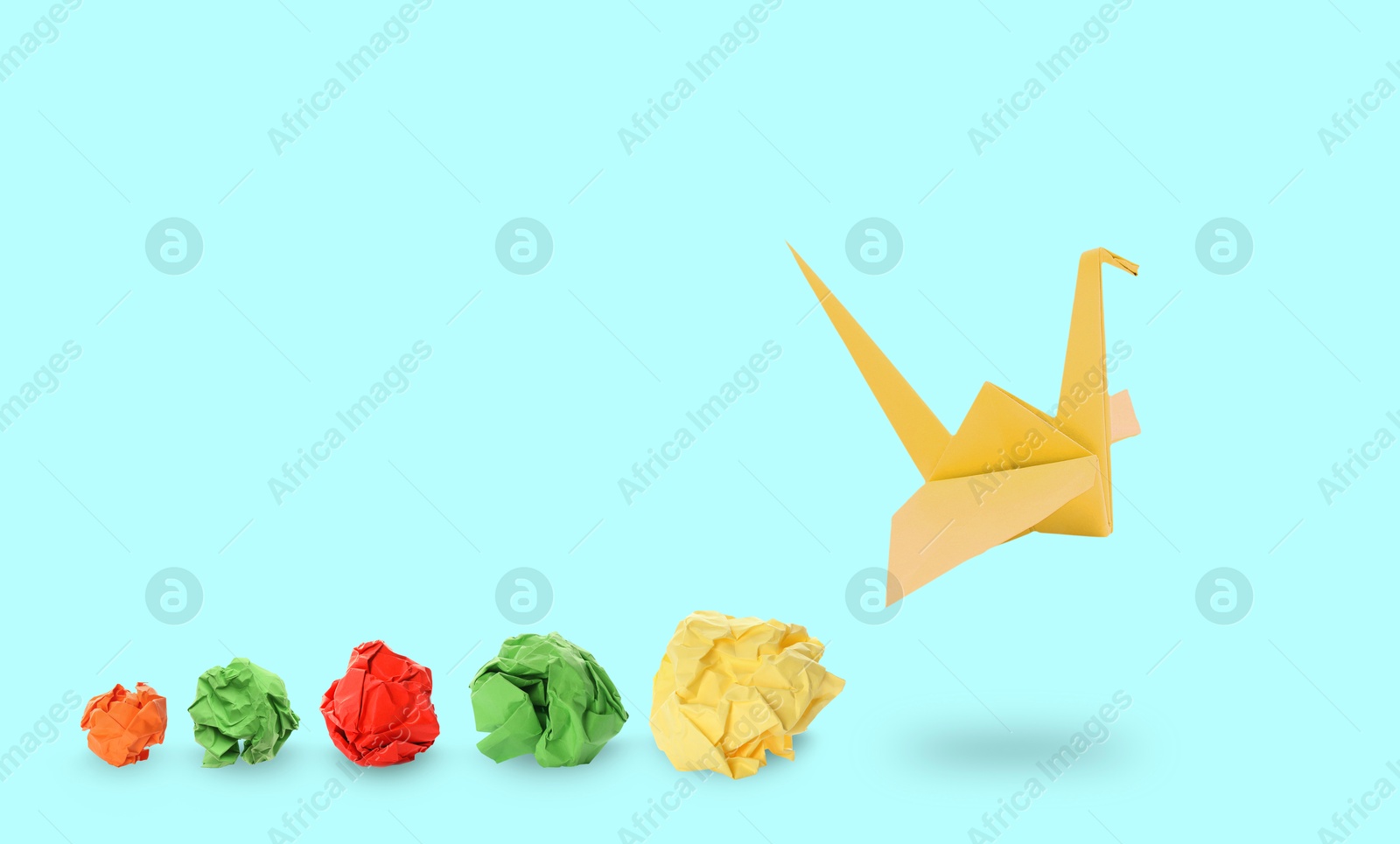 Image of Yellow origami crane and crumpled paper balls on light blue background, banner design. Transformation or new ideas concept