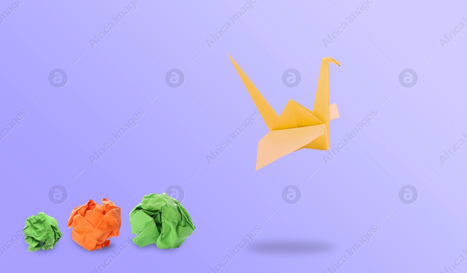 Image of Orange origami crane and crumpled paper balls on violet gradient background, banner design. Transformation or new ideas concept