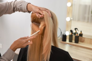 Photo of Hair cutting. Professional hairdresser working with client in salon, closeup