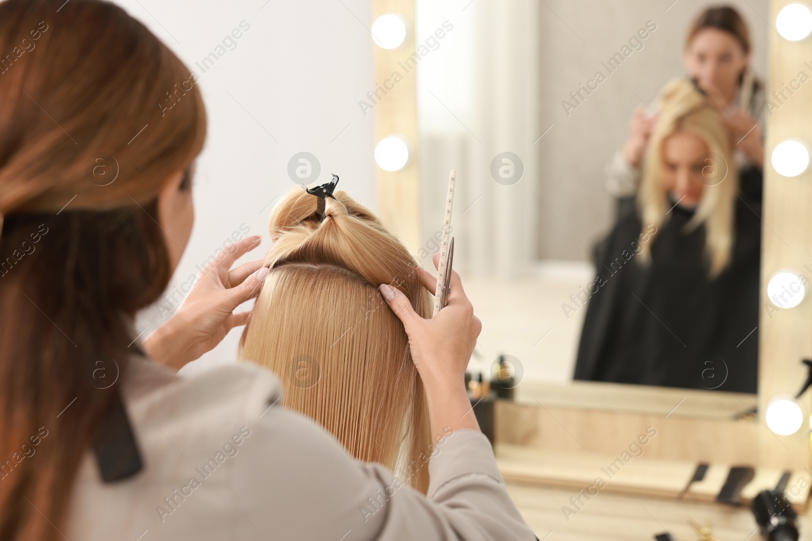 Photo of Hair cutting. Professional hairdresser working with client in salon