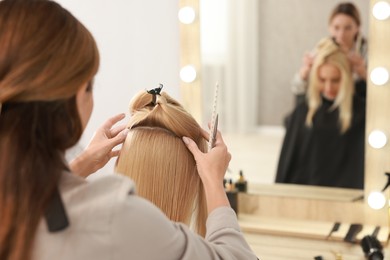 Photo of Hair cutting. Professional hairdresser working with client in salon