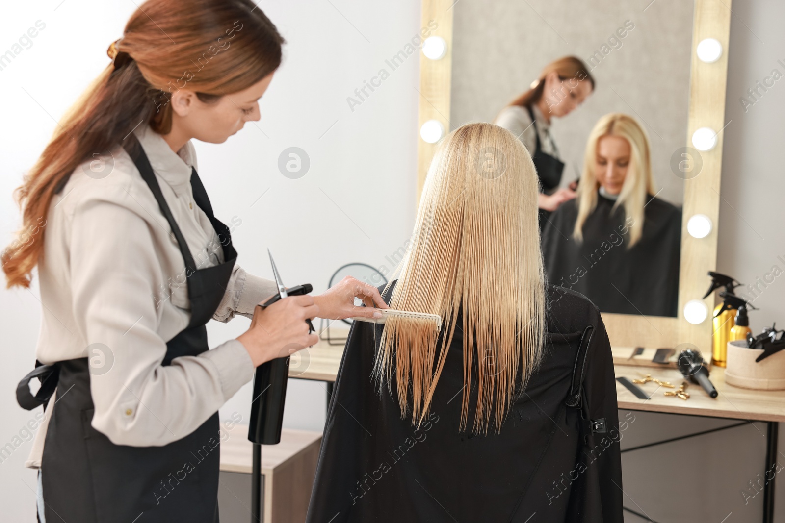 Photo of Hair cutting. Professional hairdresser working with client in salon