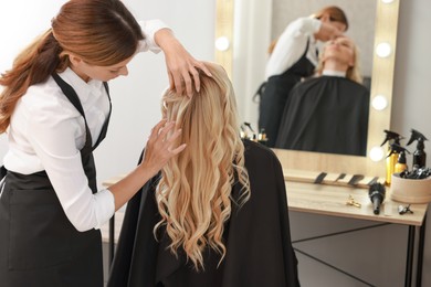 Photo of Hair cutting. Professional hairdresser working with client in salon