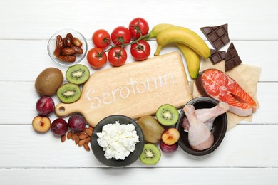 Photo of Wooden board with word Serotonin and different fresh products on white table, flat lay