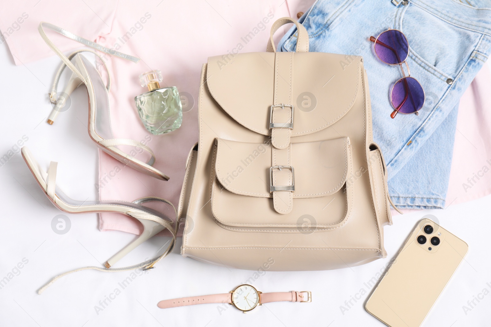 Photo of Stylish outfit with backpack on white background, flat lay