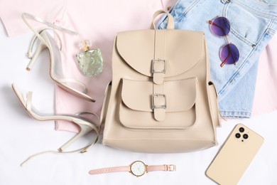 Photo of Stylish outfit with backpack on white background, flat lay