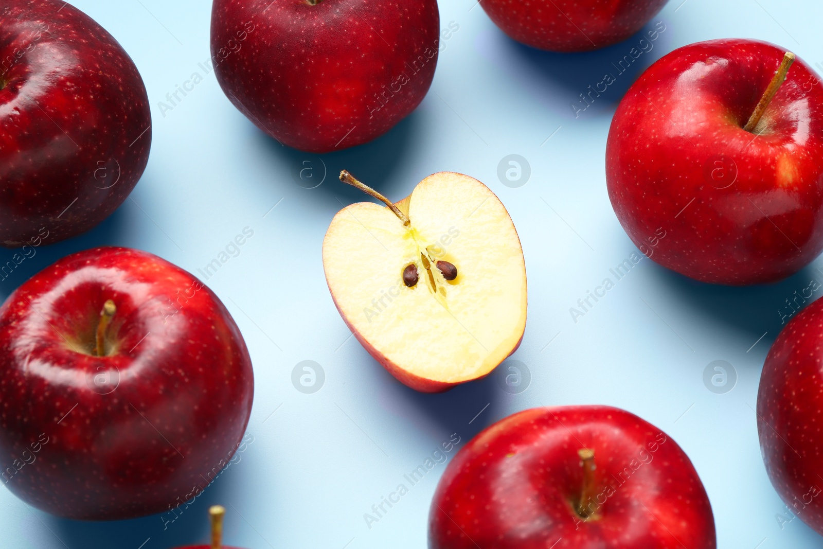 Photo of Fresh ripe red apples on light blue background