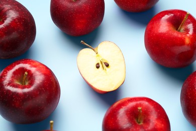 Fresh ripe red apples on light blue background