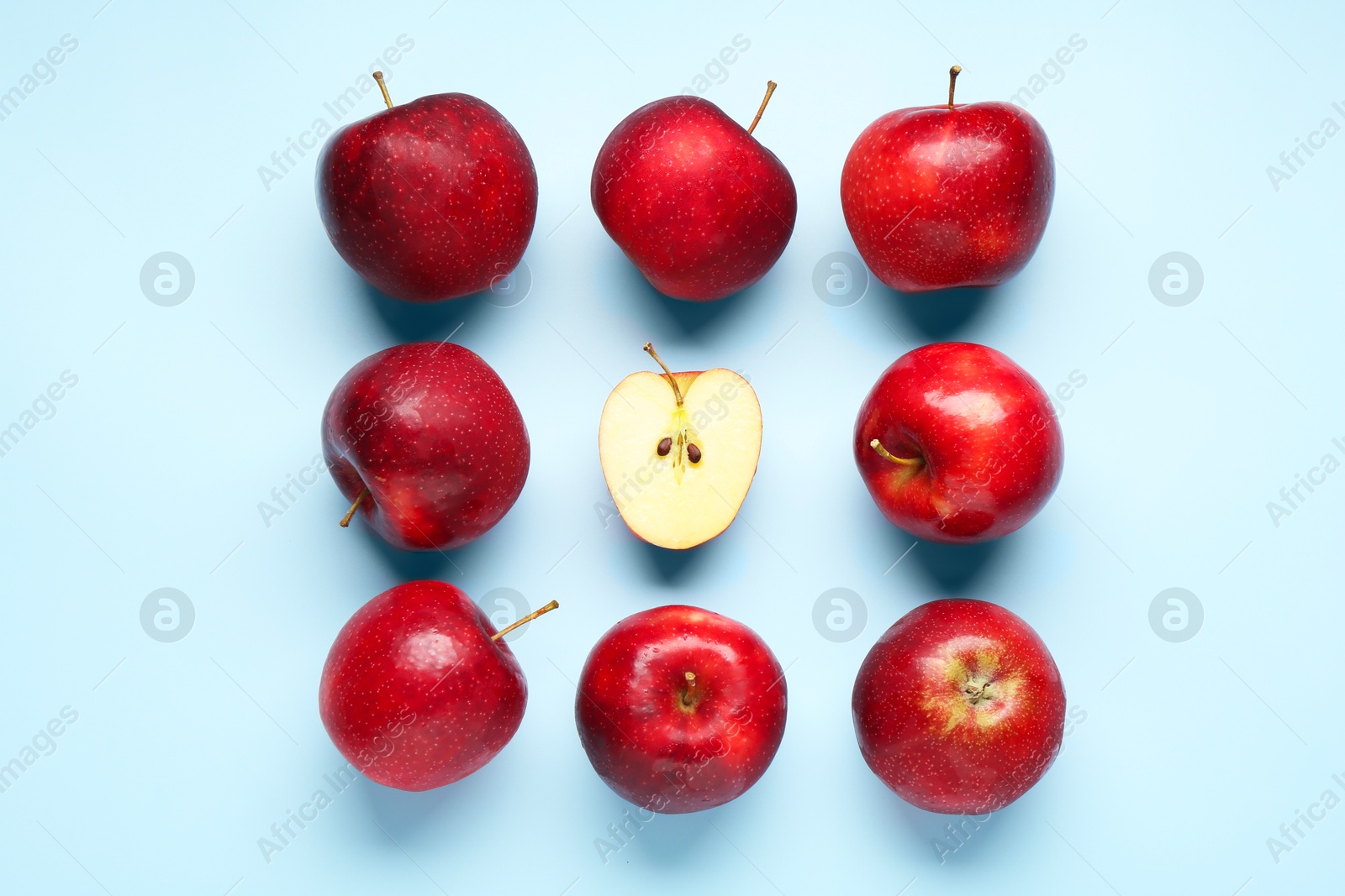 Photo of Fresh ripe red apples on light blue background, flat lay