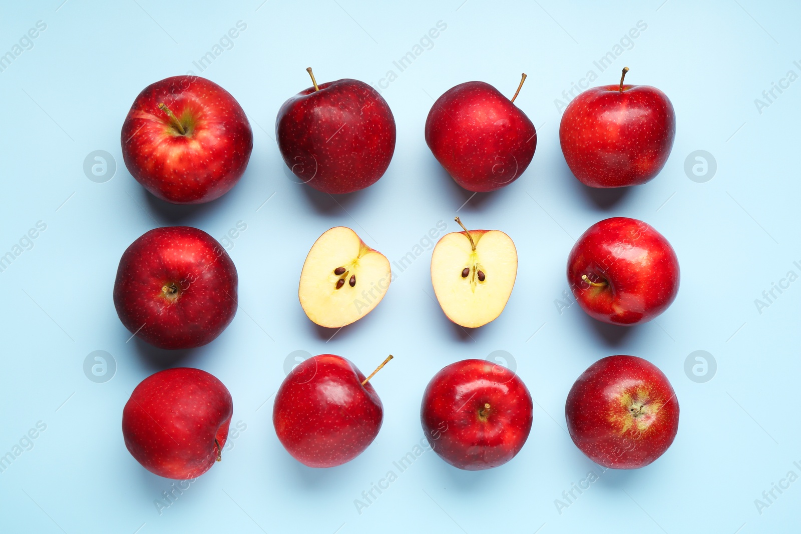 Photo of Fresh ripe red apples on light blue background, flat lay