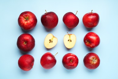 Fresh ripe red apples on light blue background, flat lay