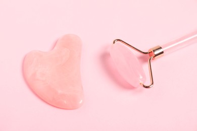 Photo of Face roller and gua sha tool on pink background