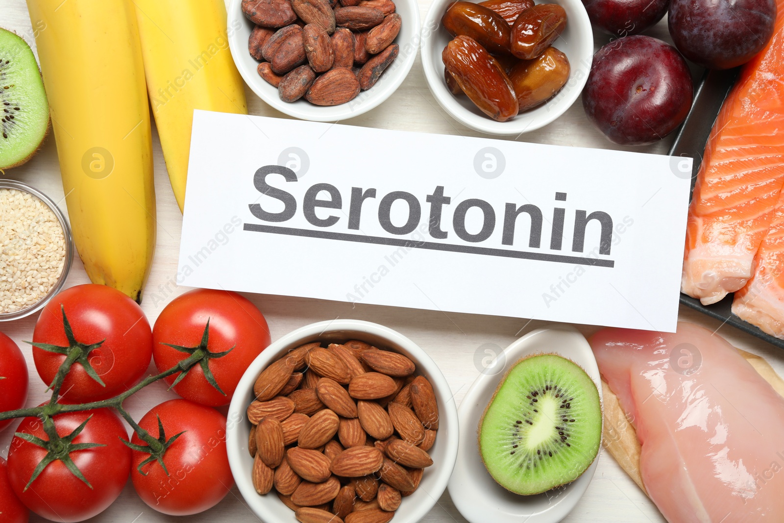 Photo of Word Serotonin and products on white table, flat lay