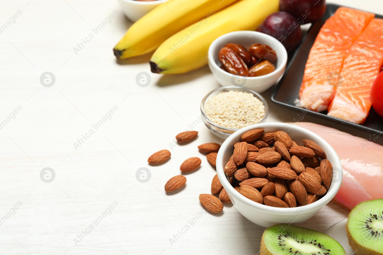 Photo of Different products rich in serotonin on white wooden table, closeup. Space for text