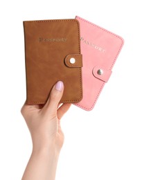 Photo of Woman holding passports in color covers on white background, closeup