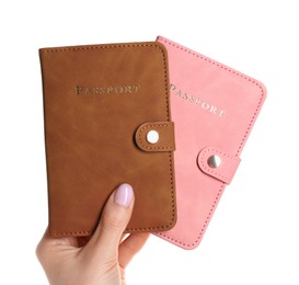 Woman holding passports in color covers on white background, closeup