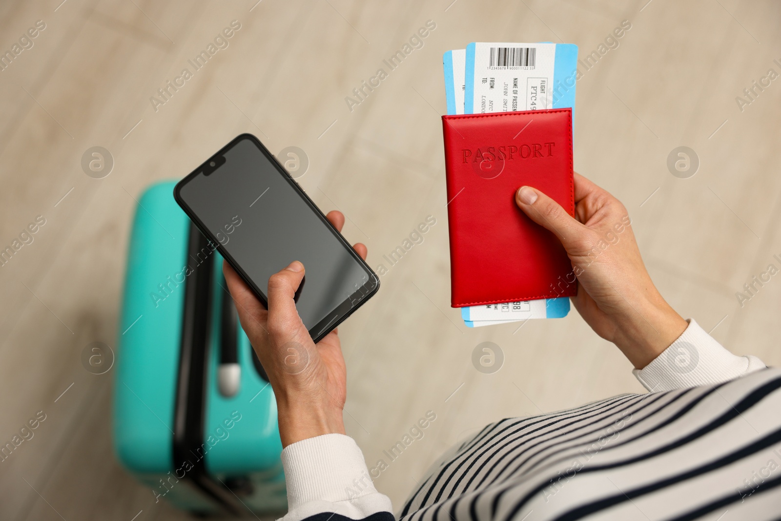 Photo of Traveller with passport, flight tickets and smartphone indoors, top view