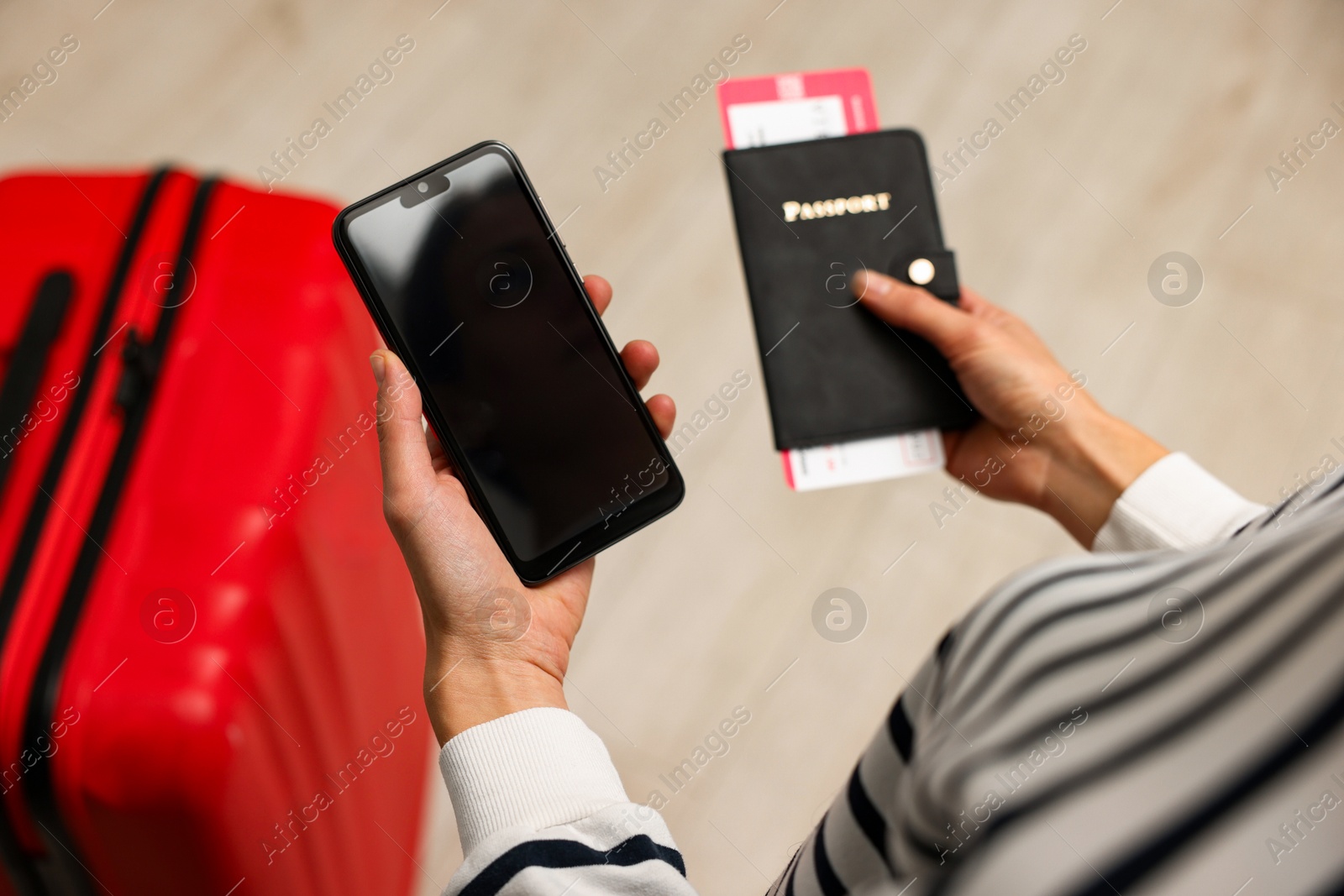 Photo of Traveller with passport, flight tickets and smartphone indoors, above view