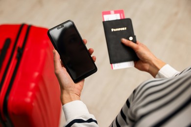 Traveller with passport, flight tickets and smartphone indoors, above view