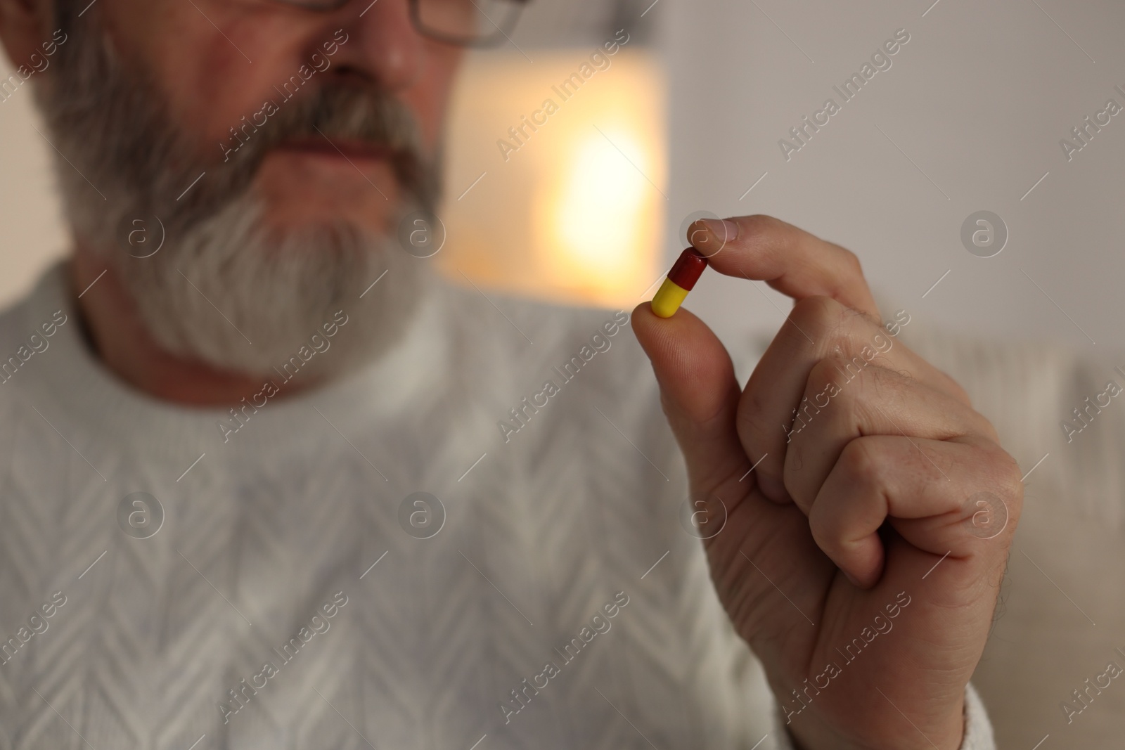 Photo of Senior man with pill at home, closeup