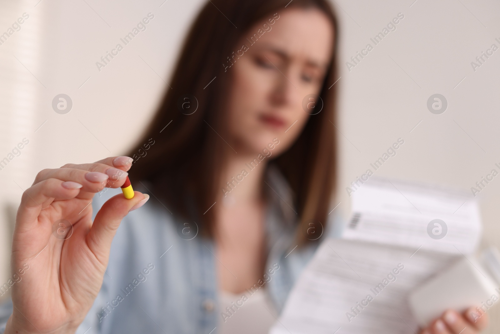 Photo of Woman with pill and instruction, selective focus