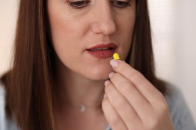 Photo of Woman taking medical pill at home, closeup