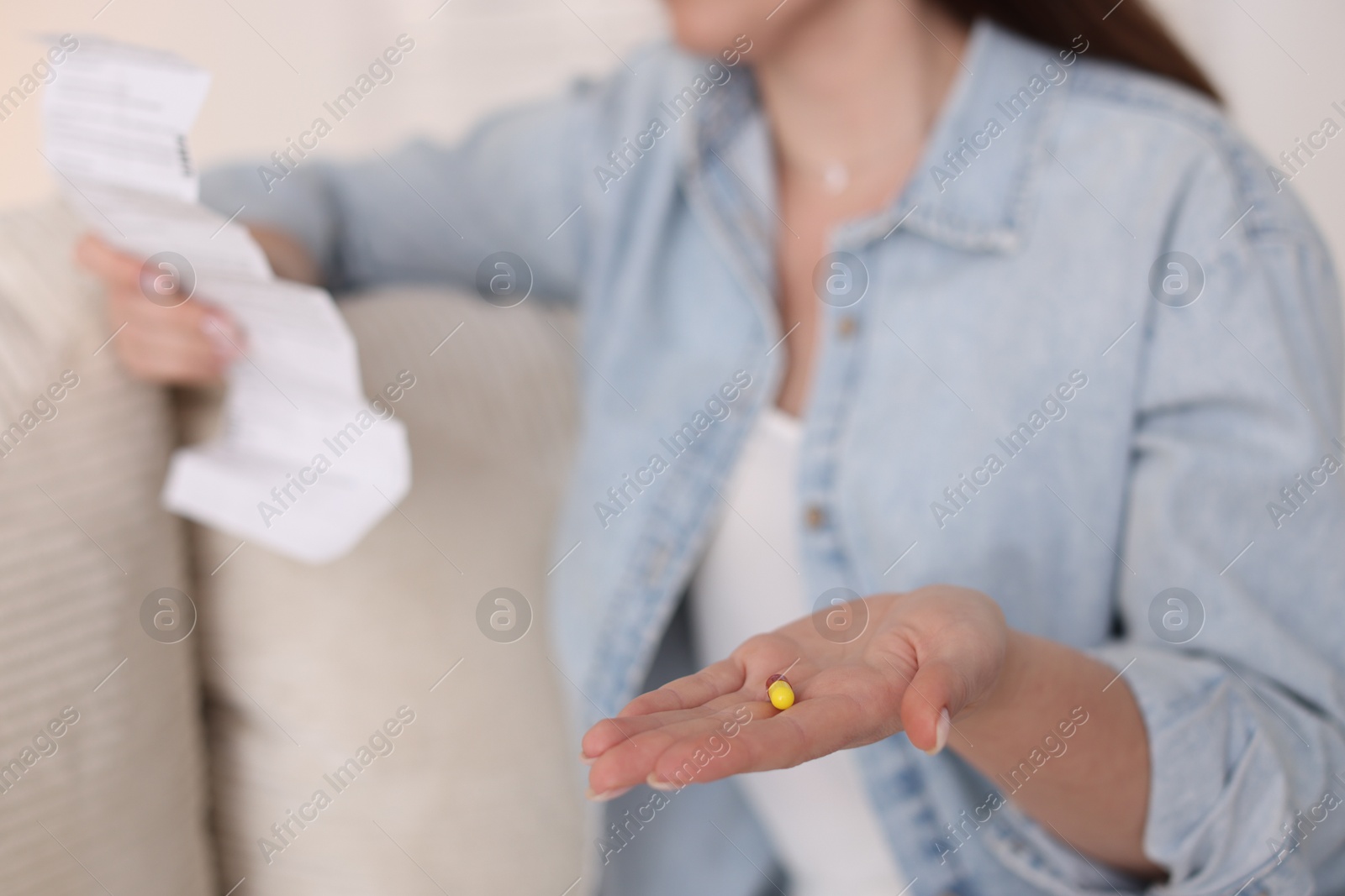 Photo of Woman with pill reading instruction indoors, selective focus