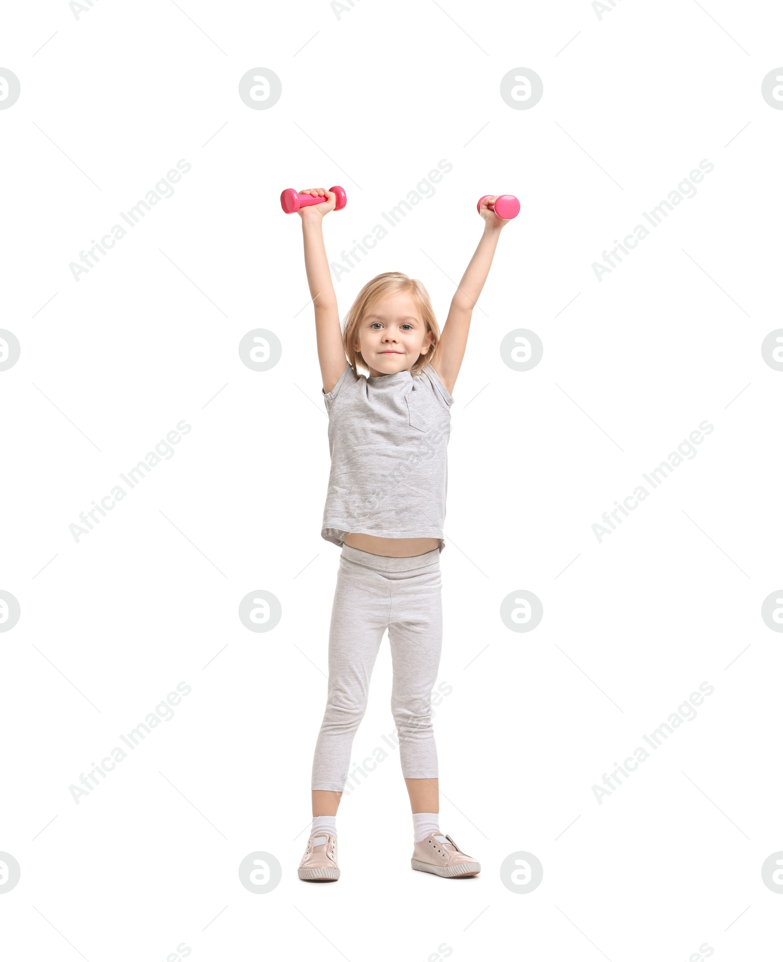 Photo of Little girl exercising with dumbbells on white background. Sport activity