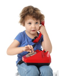 Photo of Cute little boy with telephone on stool against white background