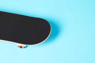 Photo of One skateboard on light blue background, space for text. Sports equipment