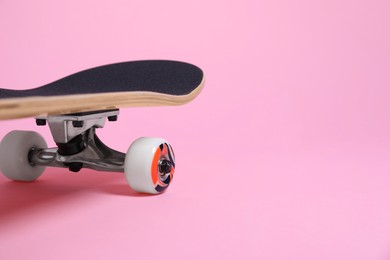 Photo of One skateboard on pink background, closeup. Space for text