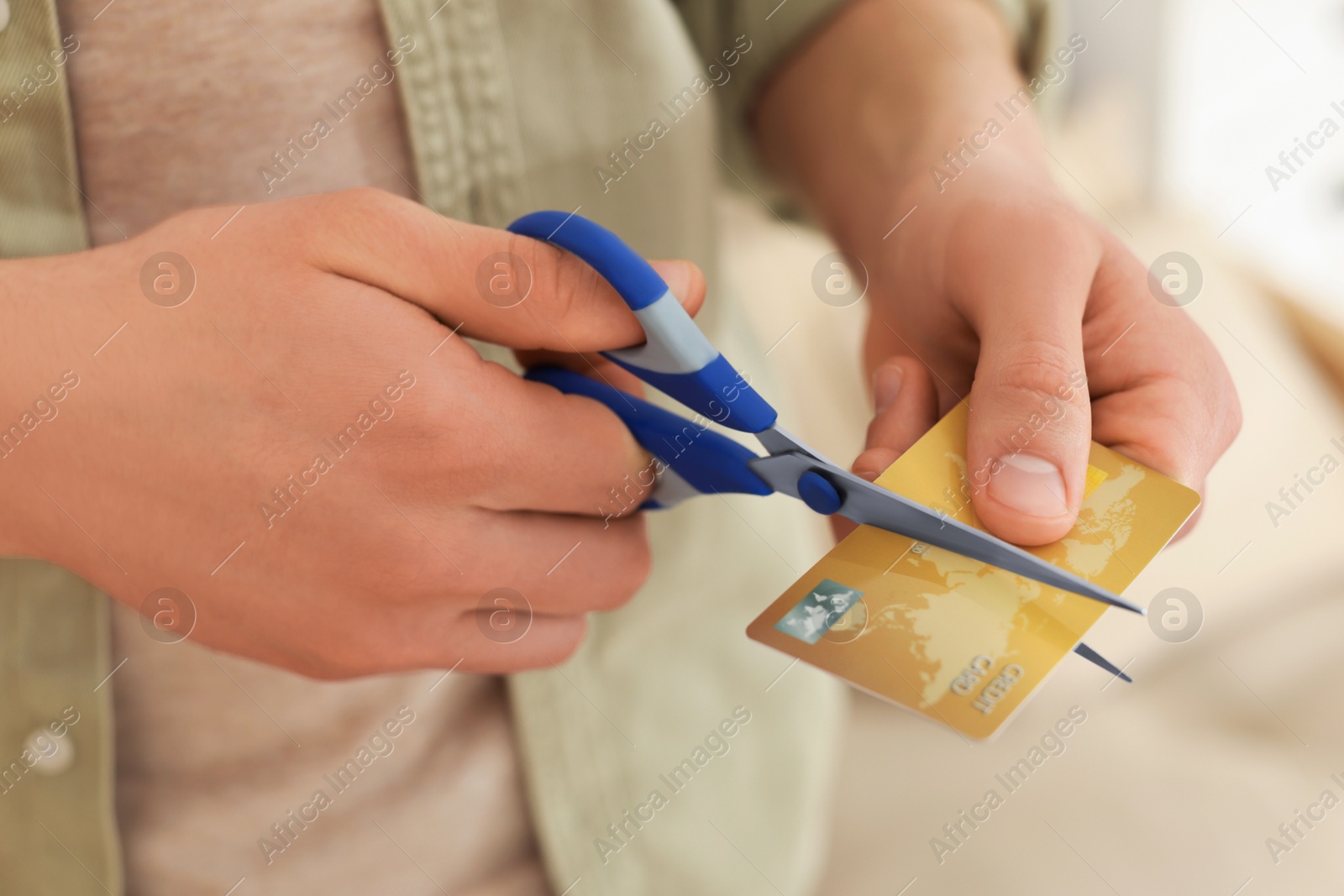 Photo of Man cutting his credit card indoors, closeup