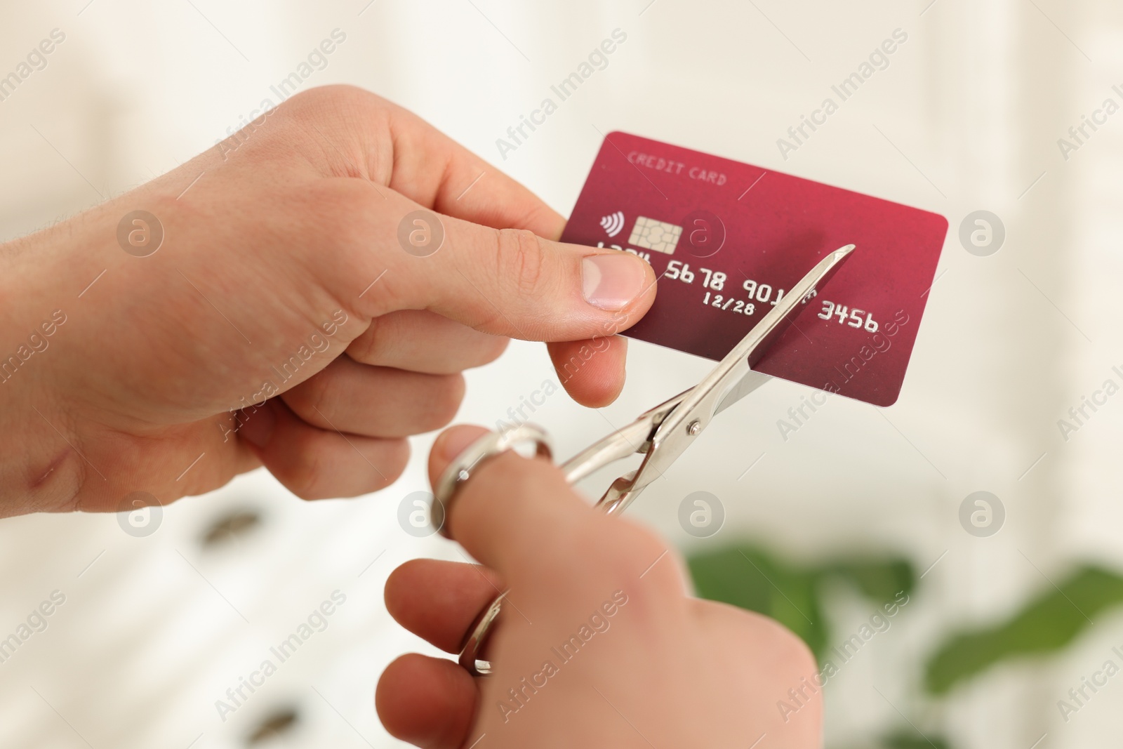 Photo of Man cutting his credit card indoors, closeup