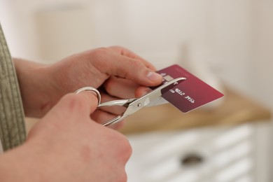 Photo of Man cutting his credit card indoors, closeup