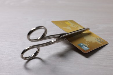 Photo of Credit card and scissors on white wooden table, closeup