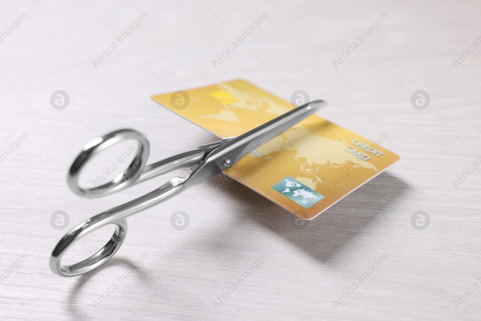 Photo of Credit card and scissors on white wooden table, closeup