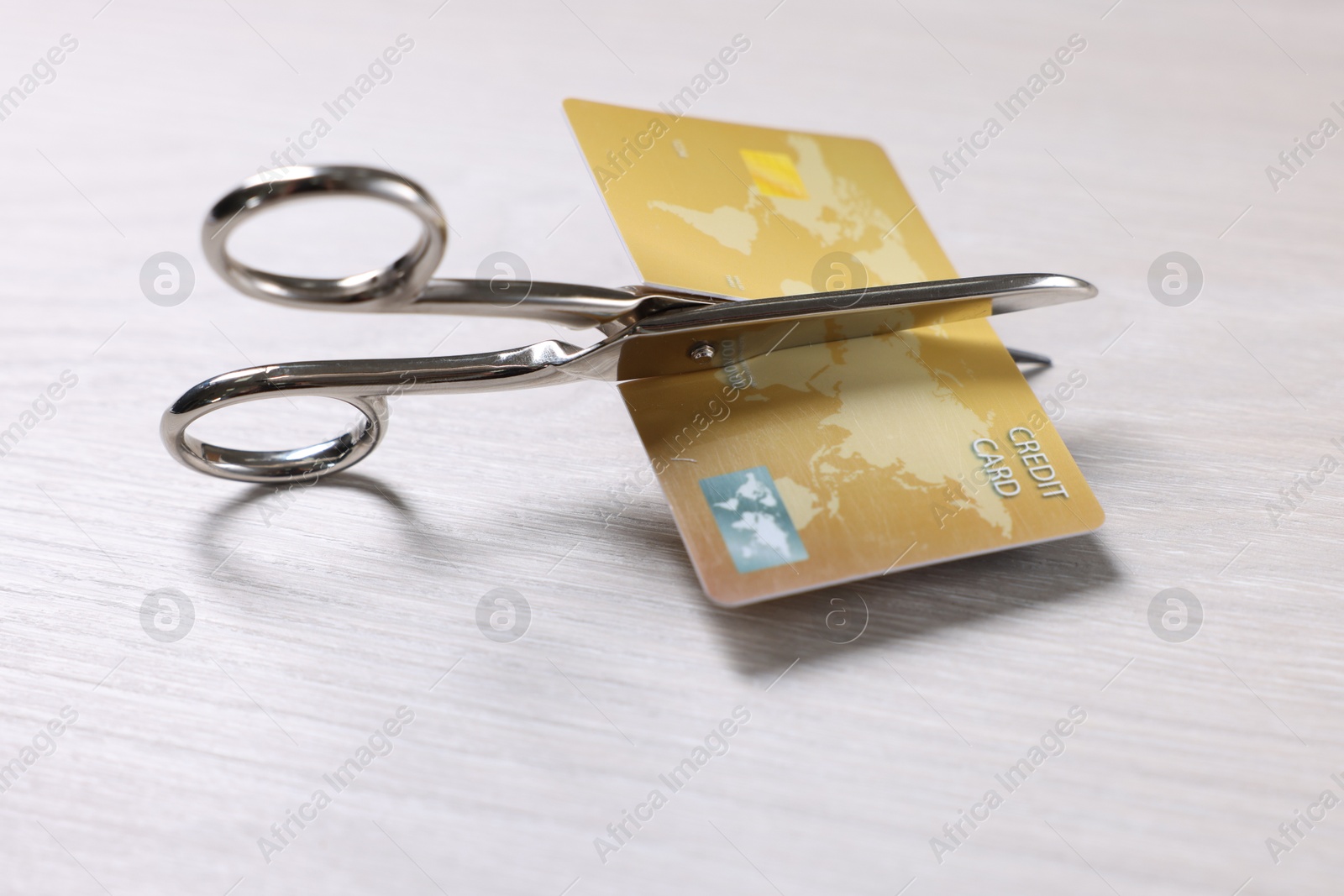 Photo of Credit card and scissors on white wooden table, closeup