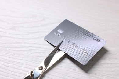 Photo of Credit card and scissors on white wooden table, closeup. Space for text