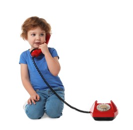 Photo of Cute little boy with telephone on white background